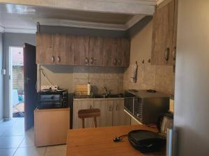 cocina con armarios de madera y encimera en Tenlet guesthouse, en Pretoria