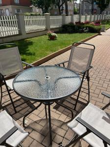 a glass table and two chairs on a patio at Appartement T3 très calme - Le Bartholdi - Centre de Colmar in Colmar