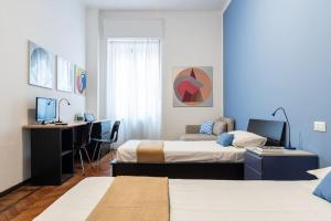 a bedroom with two beds and a desk with a computer at Piola Flexyrent apt. A.C. WiFi in Milan