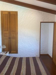 um quarto com uma cama, um armário e uma porta em A Casa di Furtunatu em Santa-Reparata-di-Balagna