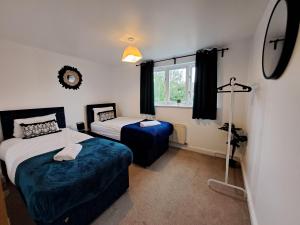 1 dormitorio con 2 camas y ventana en Milton 5BR House with free parking, 3.5 Bathrooms ideal for CONTRACTORS & WEEKEND stays, en Broughton