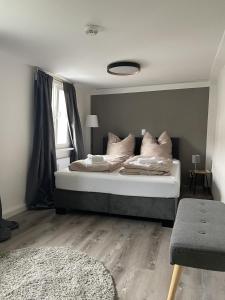 um quarto com uma cama grande com lençóis brancos e almofadas em Hotel Sleep and Eat em Hardegsen