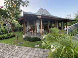 ein Haus mit einer Terrasse und einem Garten in der Unterkunft Villa Francindo in Uluwatu