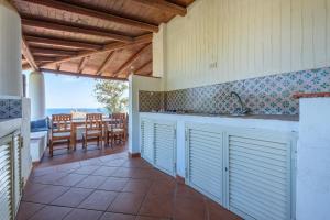 een keuken met uitzicht op een tafel en stoelen bij Jera suite vista mare 2 in Vulcano