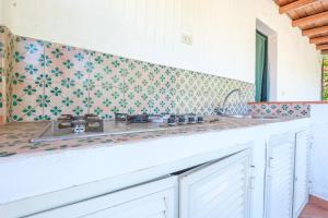 a kitchen with a sink and a tile wall at Jera suite vista mare 2 in Vulcano