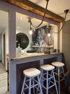a bar with stools in a kitchen with a mirror at Hotel Sleep and Eat in Hardegsen