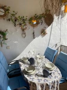 マニルバにあるMarina Duquesa apartemento 2110のテーブル(皿、食器、青い椅子付)