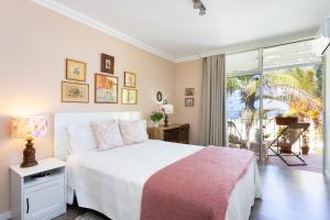 a bedroom with a white bed and a large window at Apartamento Atlanta in Puerto de la Cruz