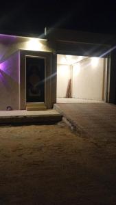 una pintura al costado de un edificio por la noche en شالية الموج الازرق قسمين, en Hafr Al Batin