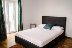 een slaapkamer met een groot wit bed en een blauw kussen bij Beach front flats in São Vicente