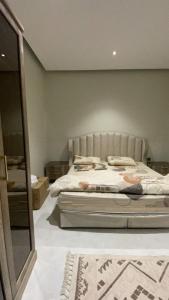 a bedroom with a bed and a mirror at شالية الموج الازرق قسمين in Hafr Al Baten