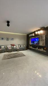 a living room with couches and a flat screen tv at شالية الموج الازرق قسمين in Hafr Al Baten