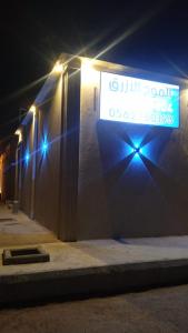 a sign on the side of a building with lights at شالية الموج الازرق قسمين in Hafr Al Baten