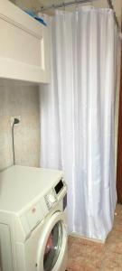 a washing machine in a kitchen with a white curtain at Appartamento Rosa in Marghera