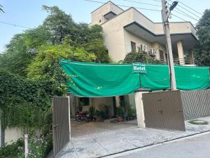 a house with a green tarp in front of it at Green Land Hotel Lahore in Lahore