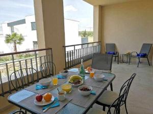 een tafel met eten en drinken op een balkon bij T2 Gardens Side Vilamoura By FHR in Quarteira