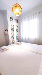 a bedroom with a large white bed with a window at THE ROOM - APARTMENT IN LLORET in Lloret de Mar