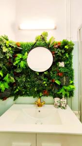 a bathroom sink with a green wall with flowers at THE ROOM - APARTMENT IN LLORET in Lloret de Mar