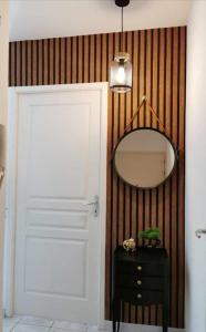 La salle de bains est pourvue d'une porte blanche et d'un miroir. dans l'établissement Le Mazette YourHostHelper, à Narbonne