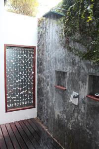 a shower with water falling off the side of a wall at Deva Beach Resort Samui in Choeng Mon Beach
