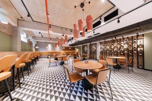 a restaurant with tables and chairs on a checkered floor at Hotel 21 in Tbilisi City