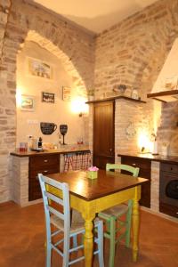 a kitchen with a wooden table and chairs at La Casina Colorata in Assisi