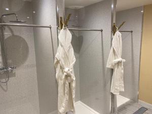 a shower with white towels on a glass door at Hollin House Hotel in Macclesfield