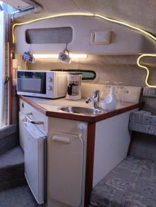 a kitchen in an rv with a sink and a microwave at Corazón Azul in Puerto Calero