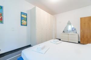 Dieses weiße Zimmer verfügt über ein Bett und ein Waschbecken. in der Unterkunft Castelletto Roomy & Functional Flat in Genua