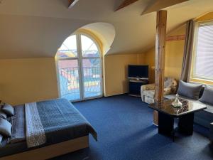 a bedroom with a bed and a couch and a table at Penzion Ariane in Prague