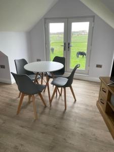 a dining room with a table and chairs and a horse outside at Hanaverian suit with amazing views of stud farm. in Great Driffield