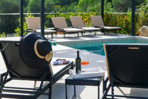 una mesa con sombrero y copas de vino junto a una piscina en Holiday home Blue Stone, en Zaostrog