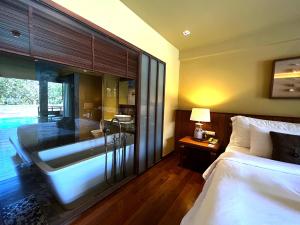 - une chambre avec une baignoire, un lit, un lit et une lampe dans l'établissement Deva Beach Resort Samui, à Choeng Mon Beach