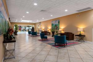 un hall avec des chaises et une salle d'attente avec dans l'établissement Ramada by Wyndham Kissimmee Gateway, à Orlando