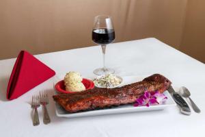 une table blanche avec une assiette de nourriture et un verre de vin dans l'établissement Ramada by Wyndham Kissimmee Gateway - Free Theme Park Shuttle, à Orlando