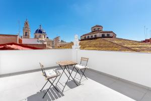 twee stoelen en een tafel op een dak bij Vilamercat in Sueca