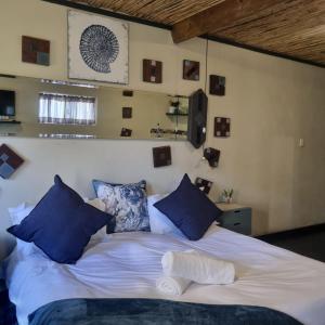 a bedroom with a large bed with blue pillows at Bedrock- Executive Self Catering Room in Cape Town +10 photos