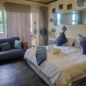 a bedroom with a large bed and a couch at Bedrock- Executive Self Catering Room in Cape Town