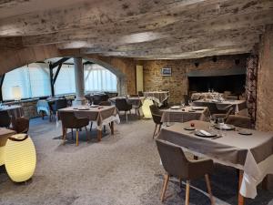 - un restaurant avec des tables et des chaises dans une salle dans l'établissement Logis Hotel La Bergerie, à Saint-Pierre-Lafeuille