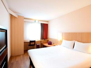 a hotel room with a bed and a television at Ibis Warszawa Ostrobramska in Warsaw