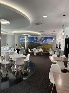 a restaurant with white tables and white chairs at ibis Styles Bielsko Biala in Bielsko-Biala