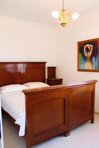 een slaapkamer met een houten bed en een schilderij aan de muur bij Re Piano appartamento I Fiori in Modigliana