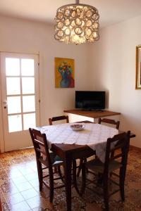 een eetkamer met een tafel en stoelen en een kroonluchter bij Re Piano appartamento I Fiori in Modigliana