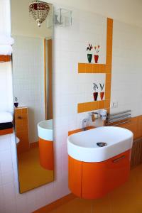 een oranje en witte badkamer met een wastafel en een douche bij Re Piano appartamento I Fiori in Modigliana