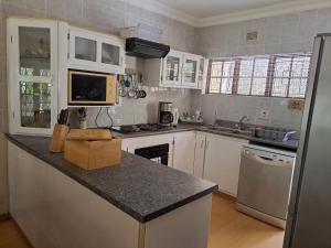 a kitchen with white cabinets and a black counter top at Eden Wilds Unit 125 in Port Edward