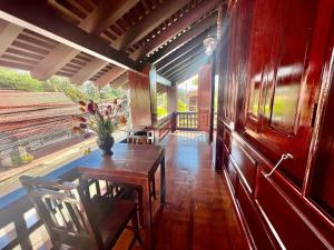 uma sala de jantar com uma mesa e um vaso de flores em Lakhang Thong Hotel em Luang Prabang