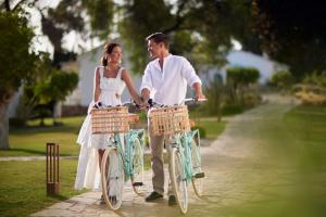 a bride and groom riding bikes down a path at Boho Club in Marbella