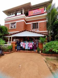 een groep mensen die voor een gebouw staan bij Redstone House by Oxystays Home Stay in Ganpatipule