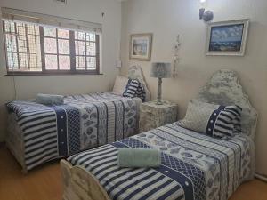 a bedroom with three beds and a window at Eden Wilds Unit 125 in Port Edward +22 photos