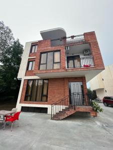 a red brick house with a table and a red chair at villa with beautiful view 2 in Tbilisi City